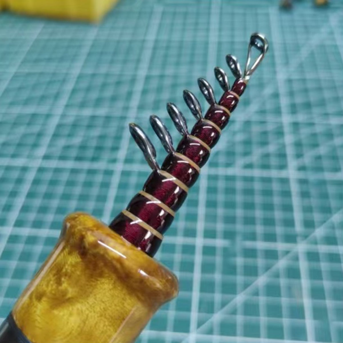 Custom compact telescopic travel rod — burgundy wrap reference; example finish.
