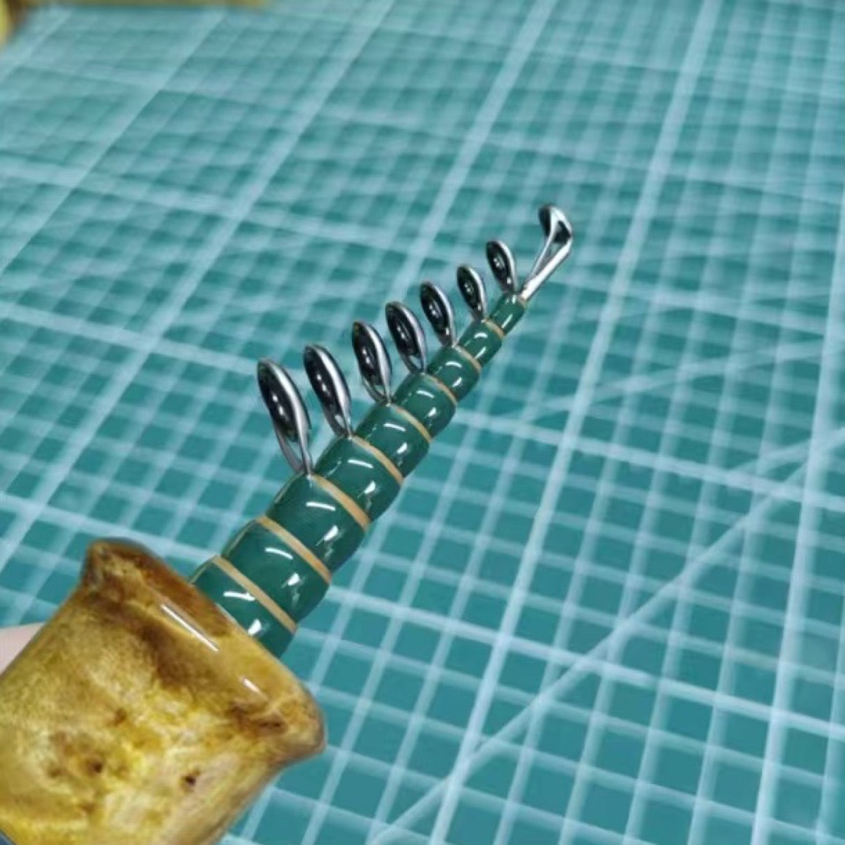Custom compact telescopic travel rod — green wrap reference; example finish.