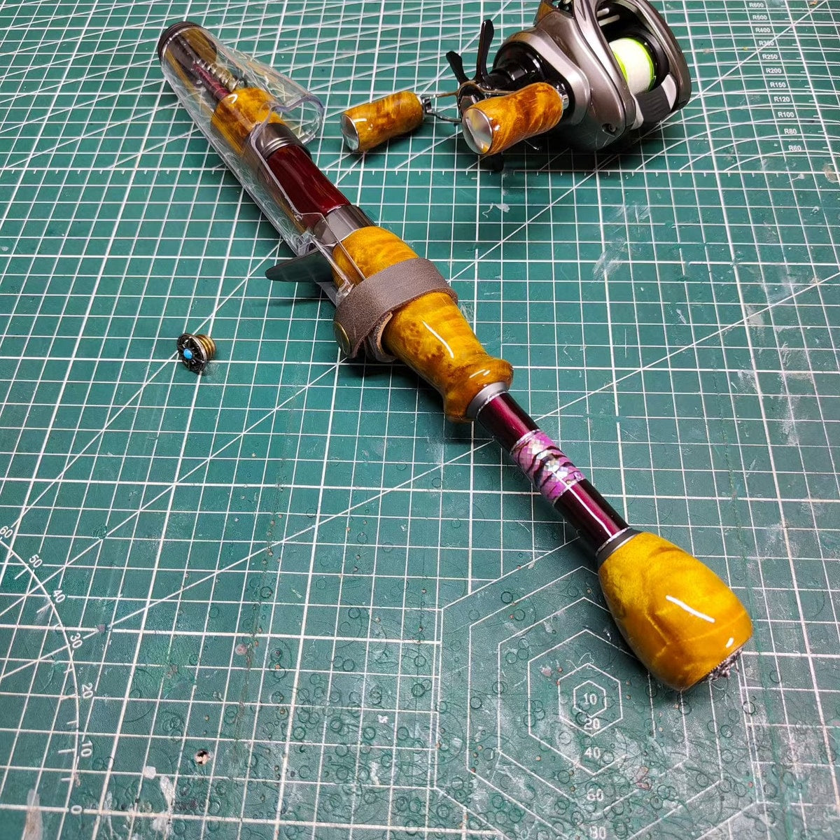 Atelier Contour with a covered collapsed tip and extended rear grip on a workbench; reel is a setup example and is not included.